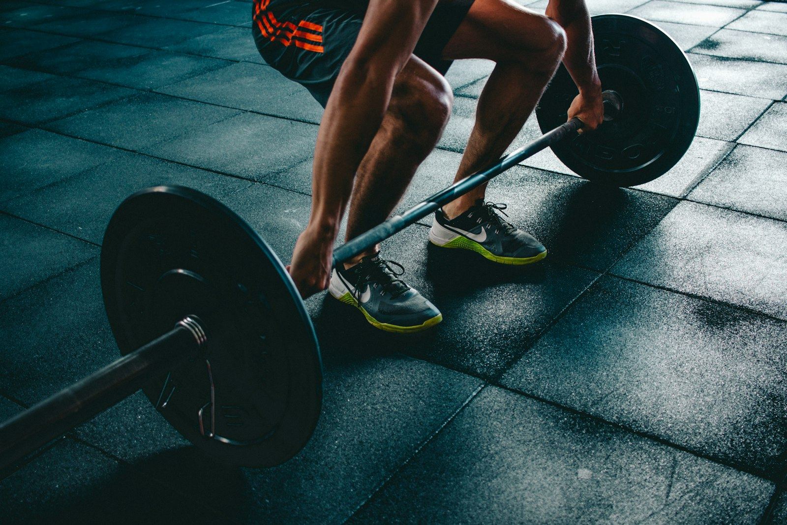 Homme s'entraînant en soulevé de terre avec des poids libres en salle de sport